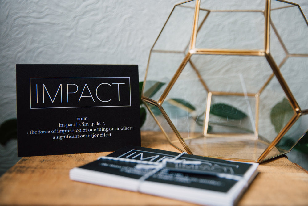 a black greeting card with the word "impact" in a box at the top followed by the definition of the word impact. The inside of the card says "thank you for making such an impact in my life"